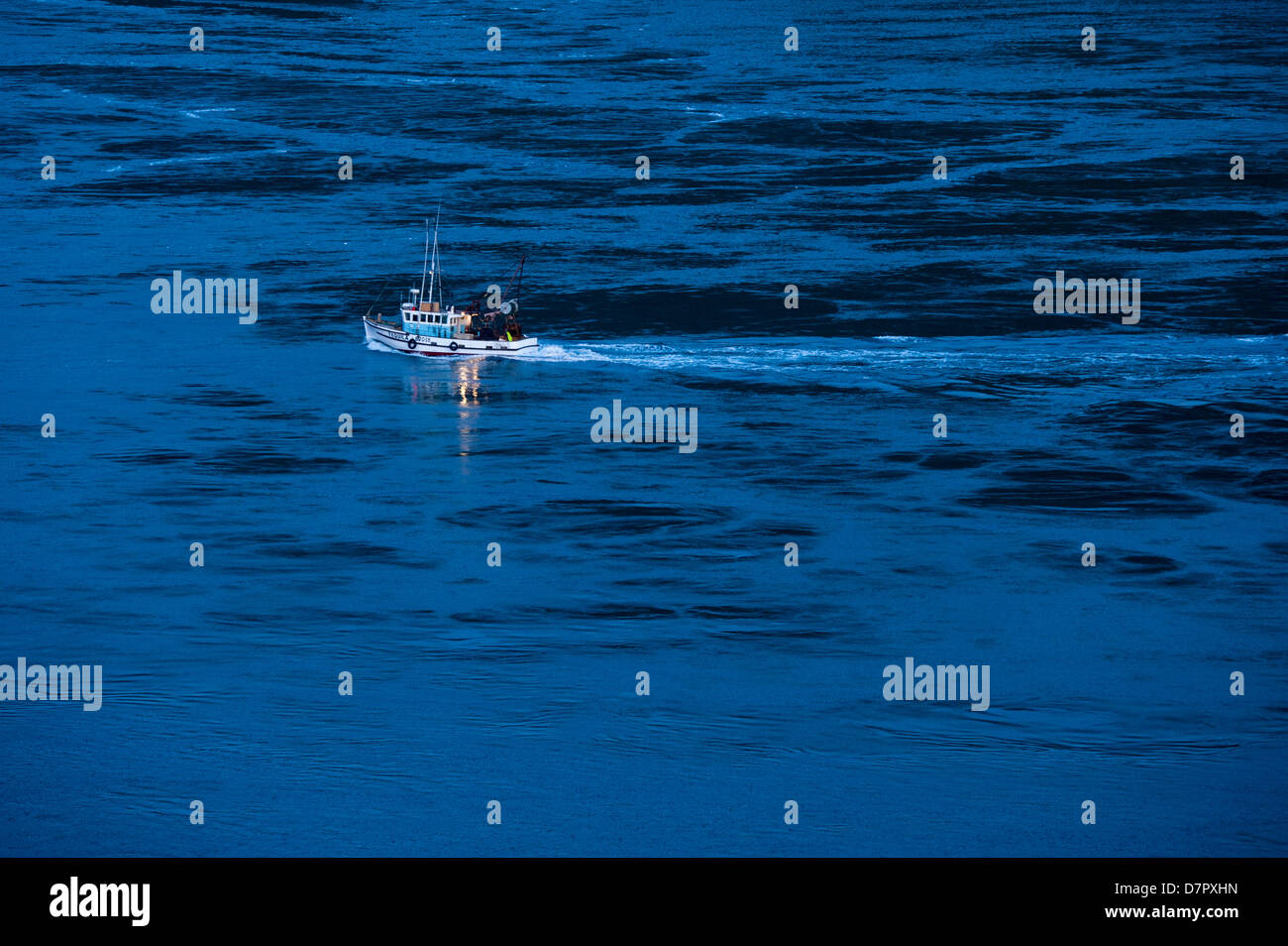 Bateau de pêche bateau à l'ouest, à l'aube à travers les tourbillons à l'entrée de la French Pass entre d'Urville Island et South Island Banque D'Images