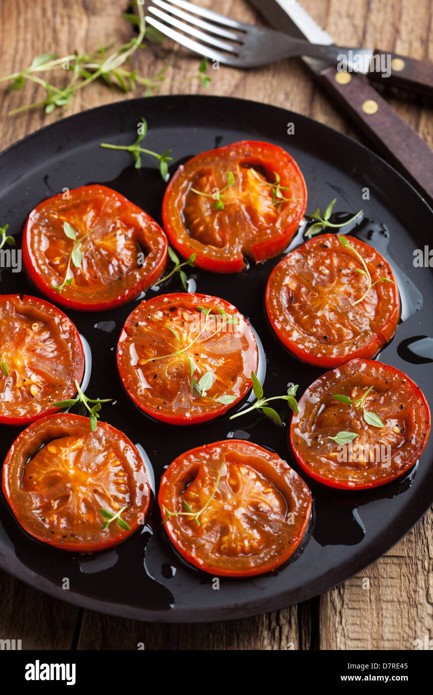 Les tomates cuites au four avec des herbes et d'huile d'olive Banque D'Images