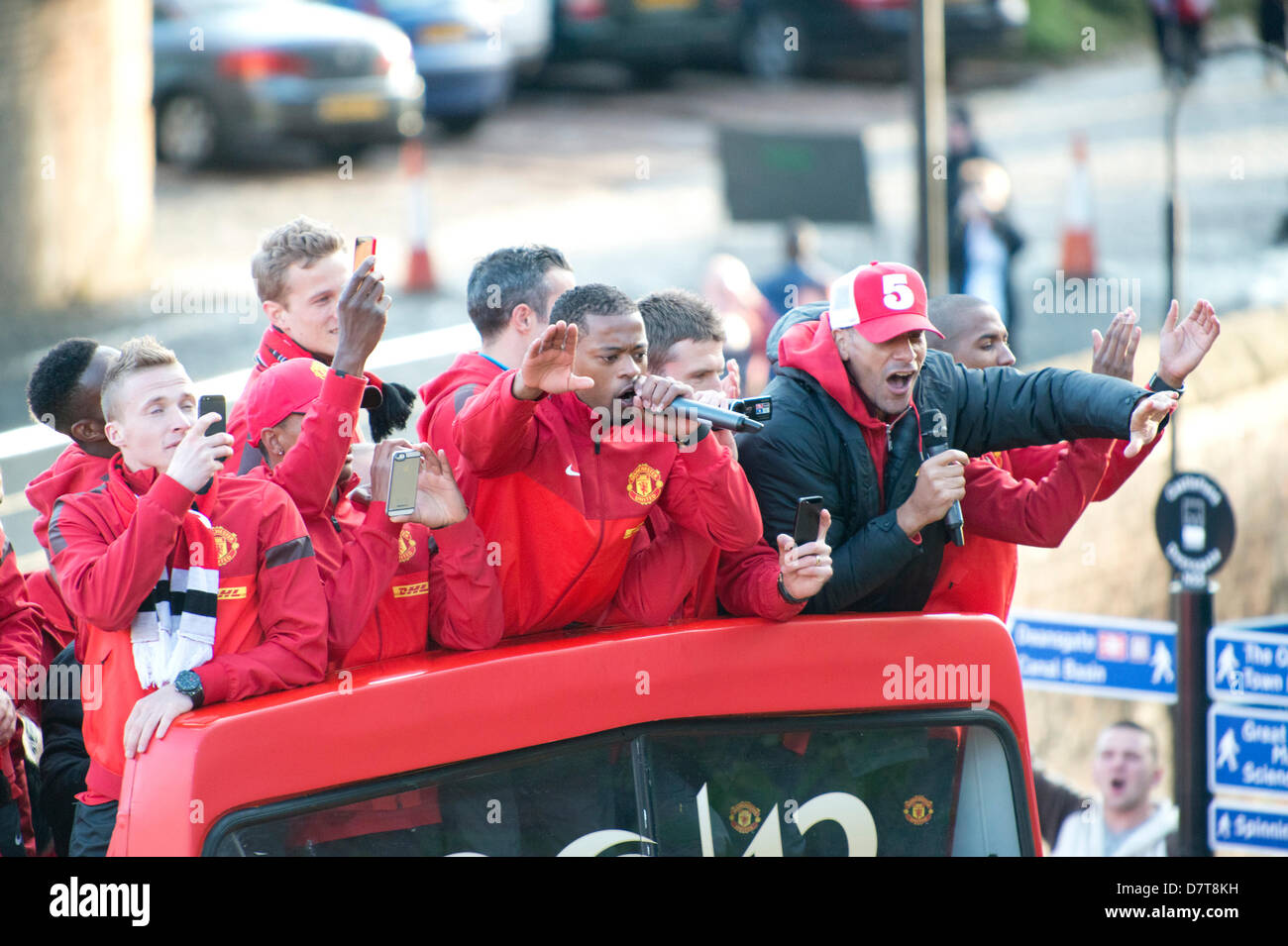 MANCHESTER, UK. Le 13 mai 2013. Manchester United left-Patrice Evra (holding microphone avec sa main gauche), orchestre le chant à partir de la plate-forme supérieure d'un bus à toit ouvert, qui célèbre le succès de Manchester United à devenir les champions de la Barclays Premier League anglaise. Le chant est également défenseur central Rio Ferdiand (port numéro 5 cap). News : Crédit du Nord Photos/Alamy Live News (usage éditorial uniquement). Banque D'Images