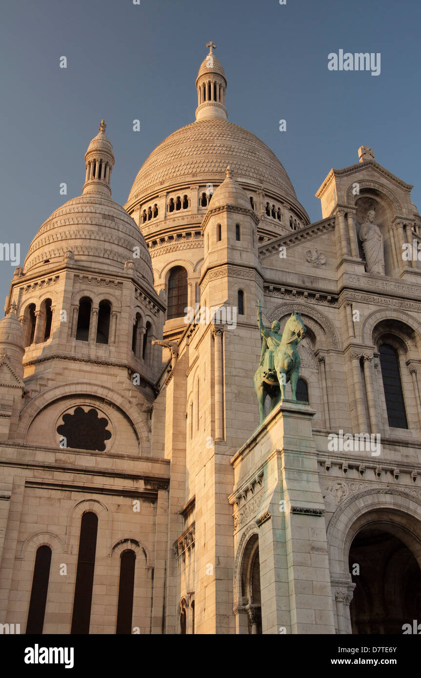 La façade et les imposantes coupoles blanches de la basilique d'Sacra-Coeur à Montmartre. Au-dessus du portique, est une statue du roi Saint Louis. Paris, France. Banque D'Images