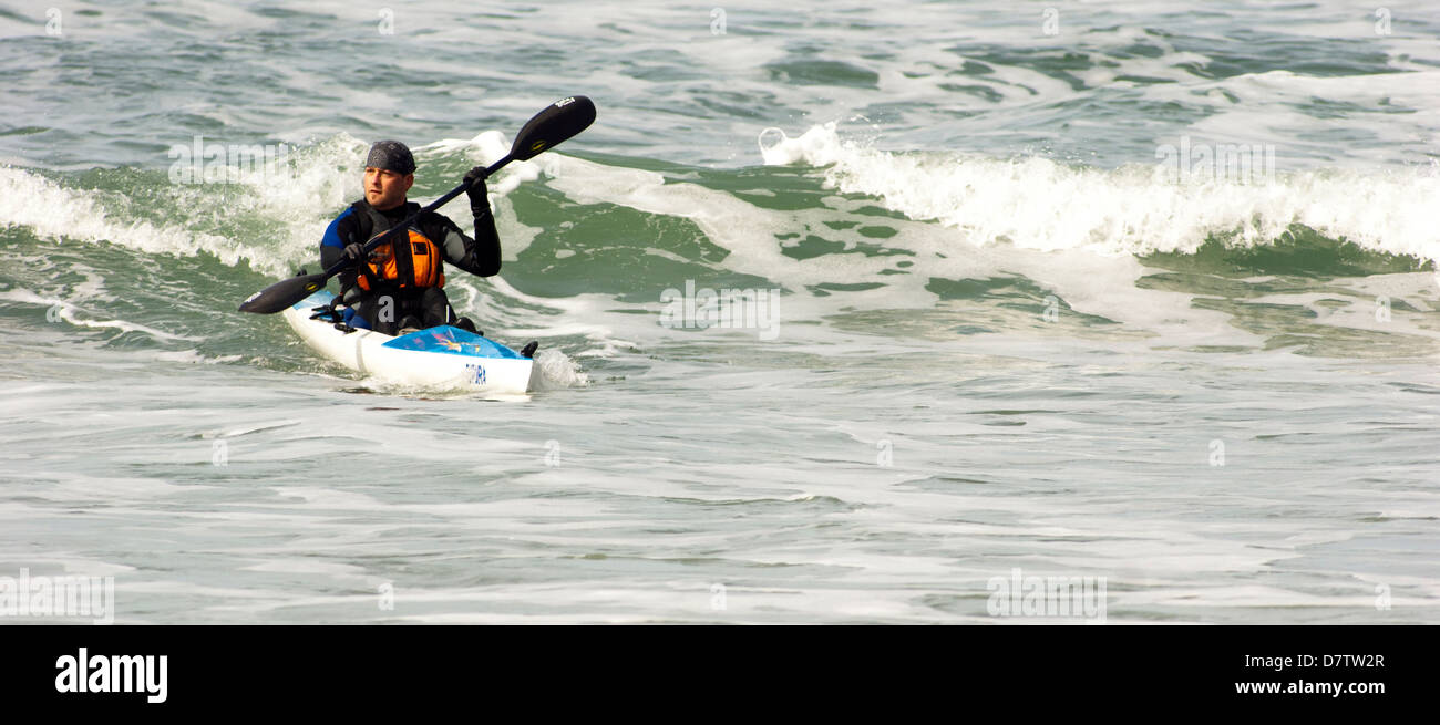 Kayakiste de mer les promenades en haut d'une vague près de Oceanside Oregon sur l'Océan Pacifique Banque D'Images