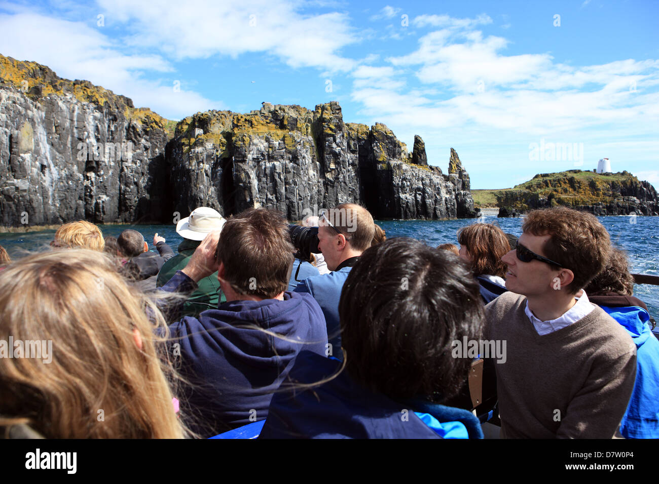 Les touristes sur un bateau à la recherche d'oiseaux sur les falaises de l'île de mai dans le Firth of Forth en Ecosse Banque D'Images