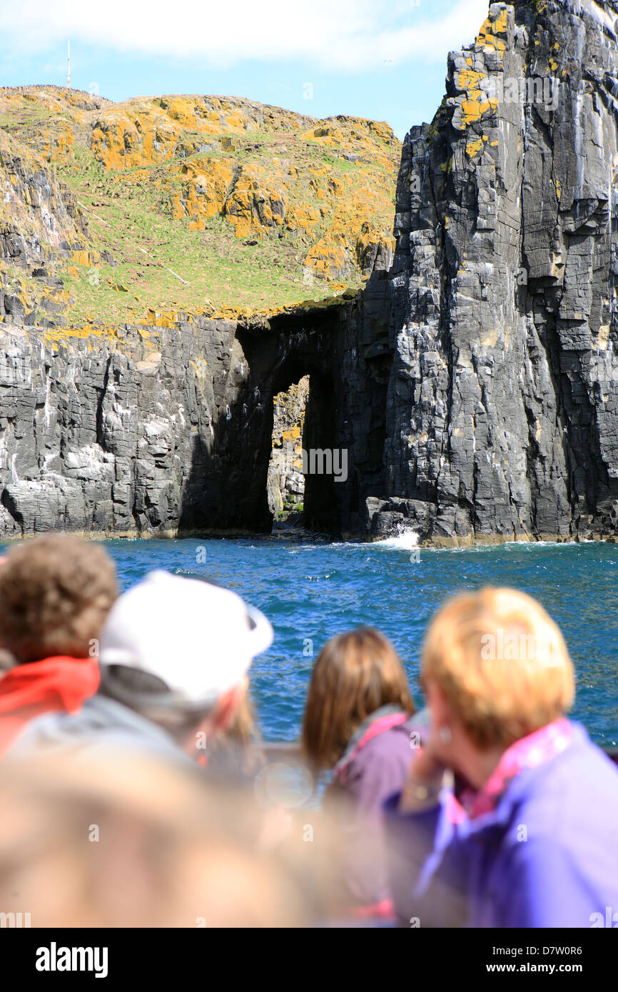 Les touristes sur un bateau à la recherche d'oiseaux sur les falaises de l'île de mai dans le Firth of Forth en Ecosse Banque D'Images