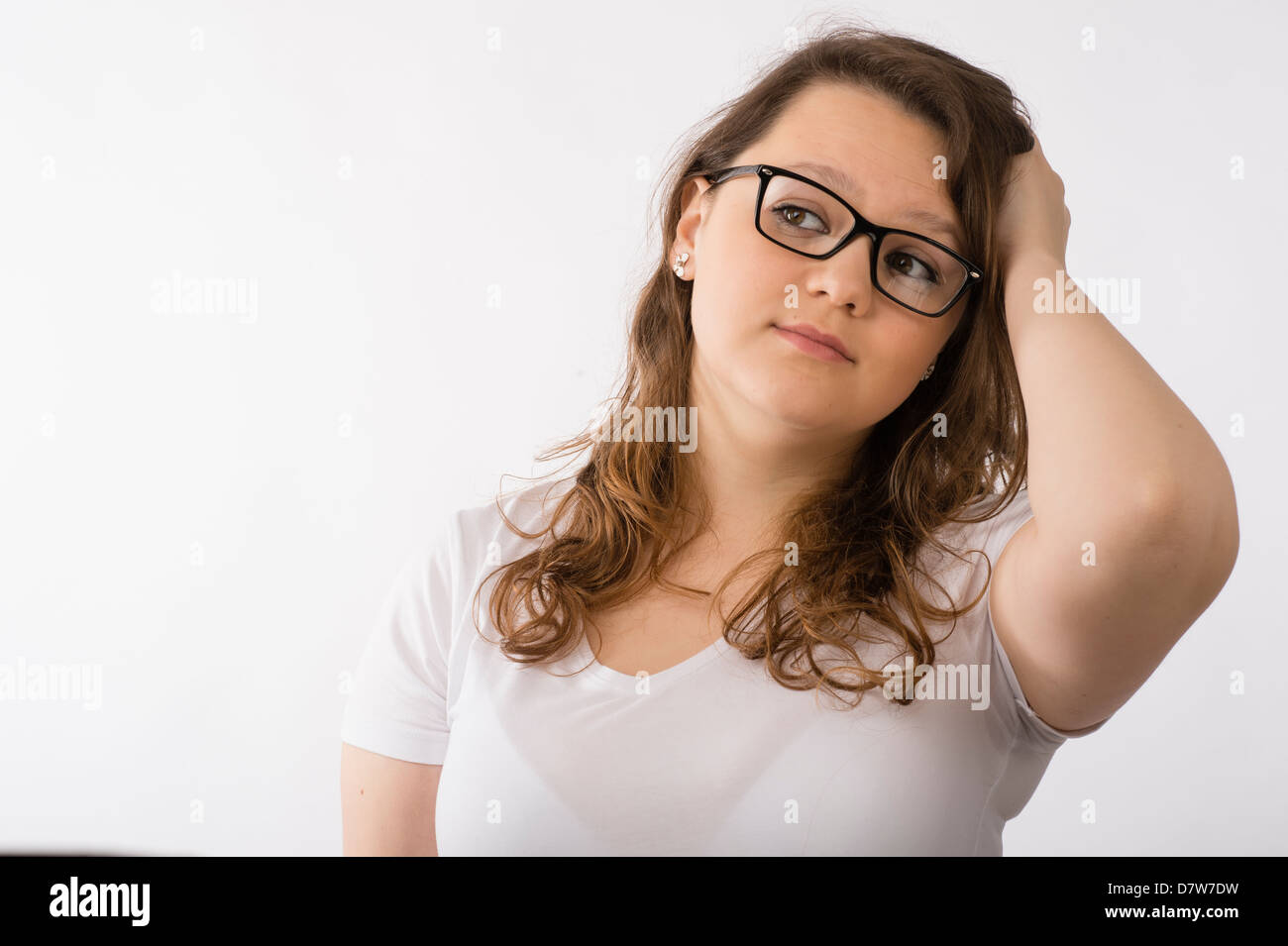 Une jeune brunette young woman wearing glasses confondu concerné se gratter la tête Banque D'Images