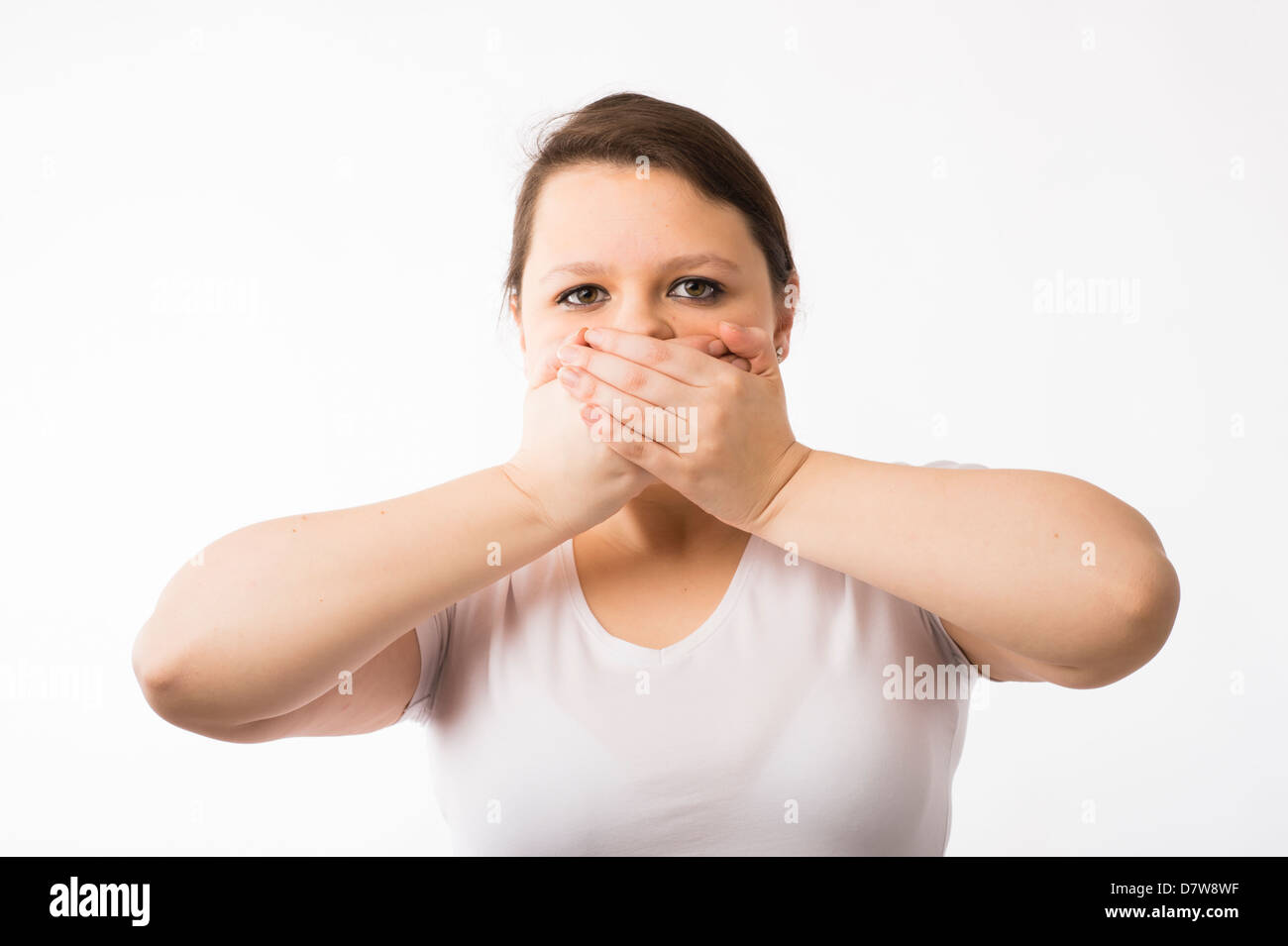 Dire : Une jeune brunette young Caucasian girl avec ses mains sur sa bouche Banque D'Images