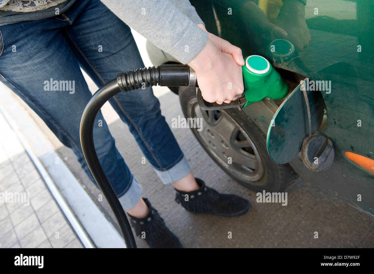 Une femme est dans sa voiture en carburant à une station de charge Banque D'Images