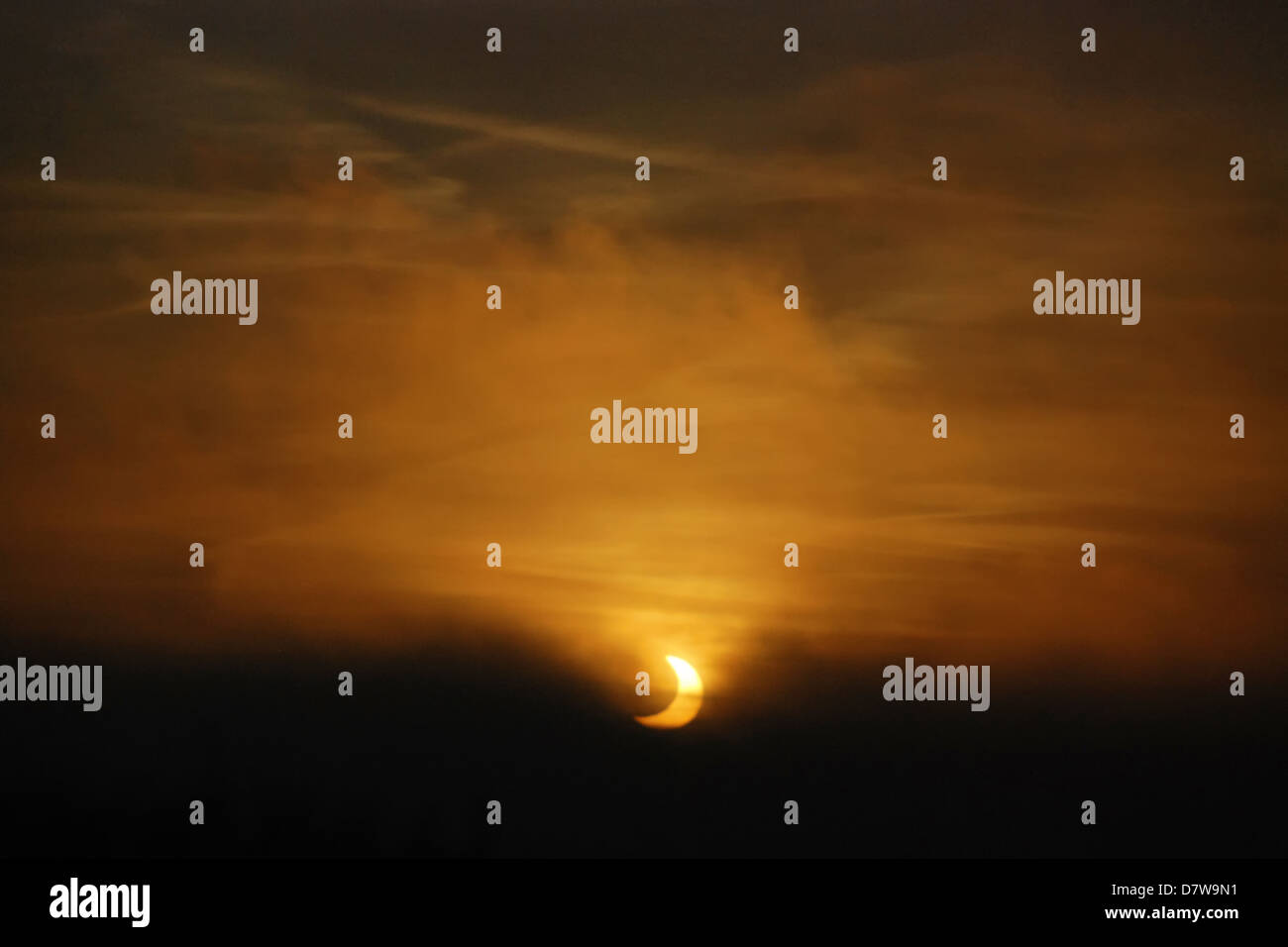 Éclipse partielle du soleil vu à travers le brouillard au lever du soleil Banque D'Images