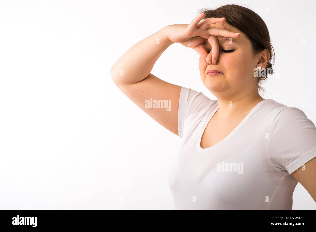 Une jeune brunette young woman holding pincer son nez pour tenir à une mauvaise odeur odeur Banque D'Images