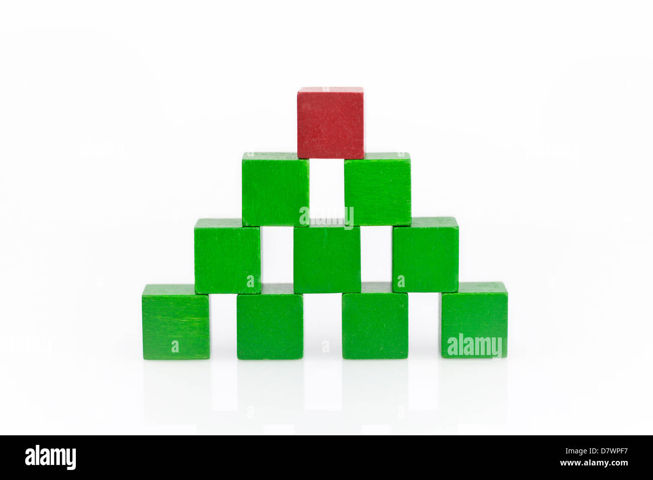 Pyramide faite de blocs de bois vert avec un rouge sur le dessus. Banque D'Images