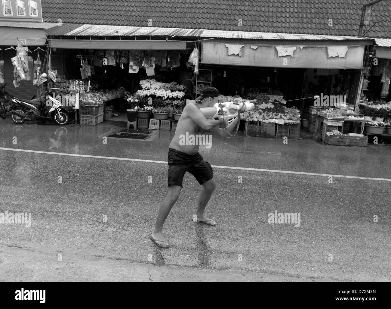 PHUKET, Thaïlande 13 AVRIL 2013 : un touriste étranger acquiert une cible pour son canon à eau pendant Songkran 2013 à Phuket. Banque D'Images