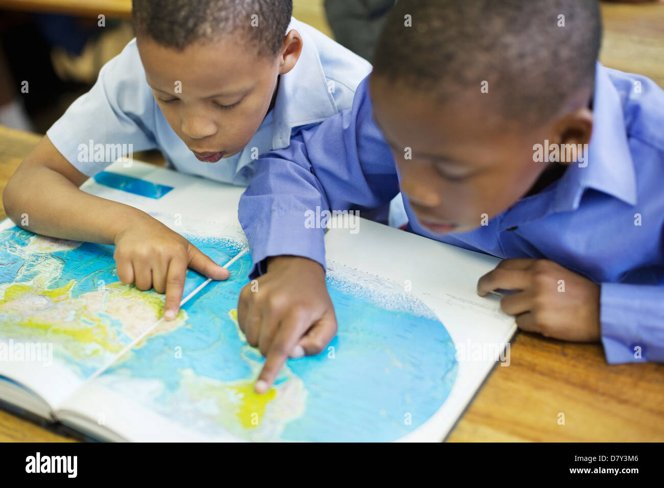 Les élèves à l'aide de la carte du monde en classe Banque D'Images