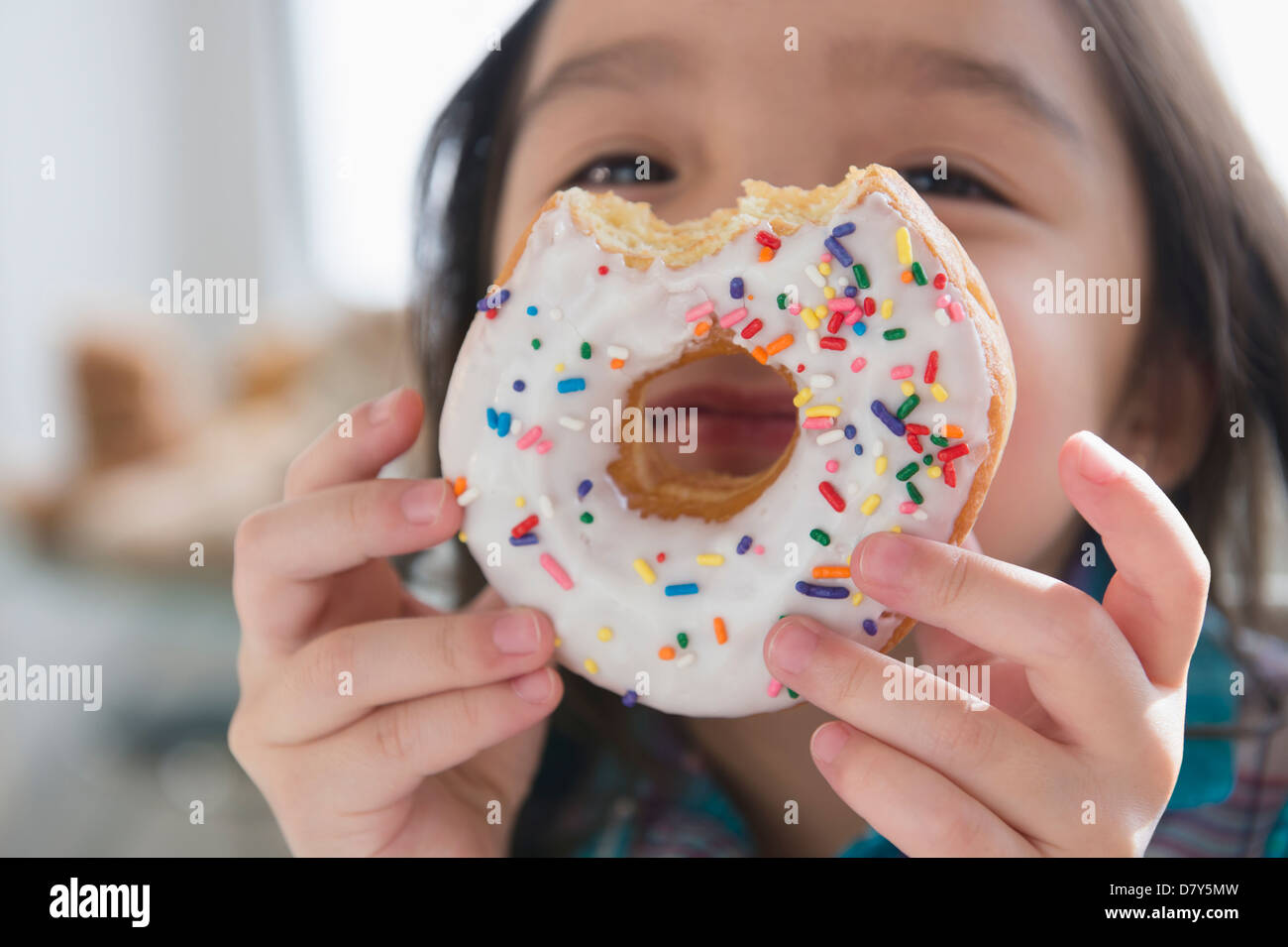 Asian girl peeking through donut hole Banque D'Images