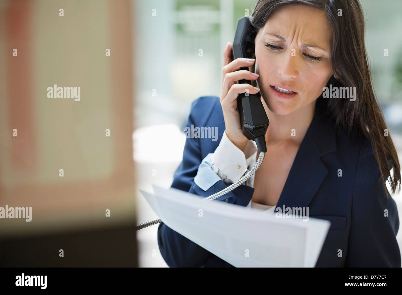 Businesswoman talking on phone in office Banque D'Images