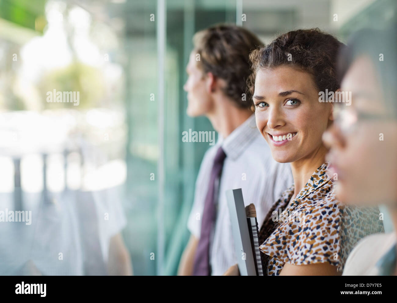 Businesswoman smiling at office window Banque D'Images