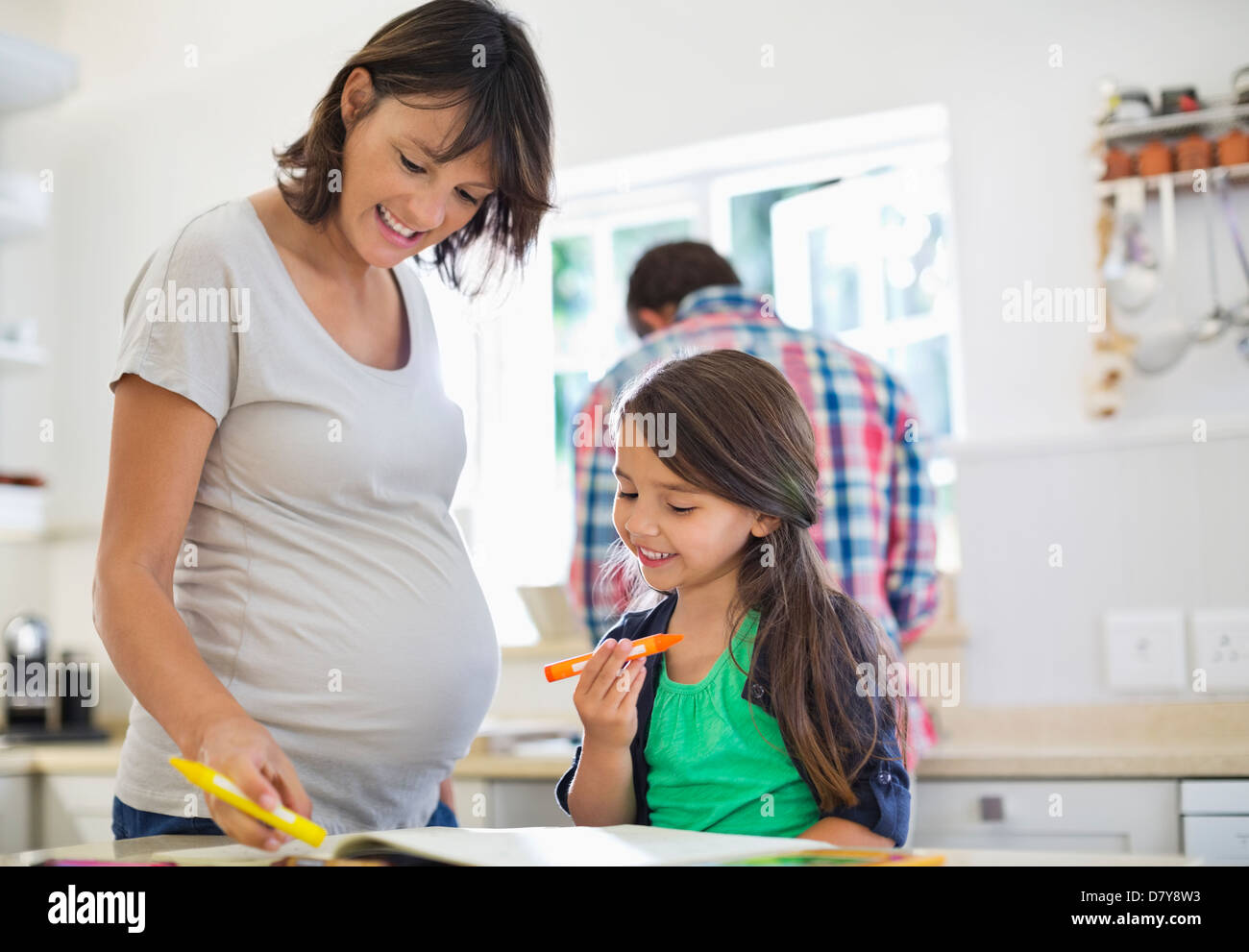 Mère enceinte fille aidant à faire leurs devoirs Banque D'Images