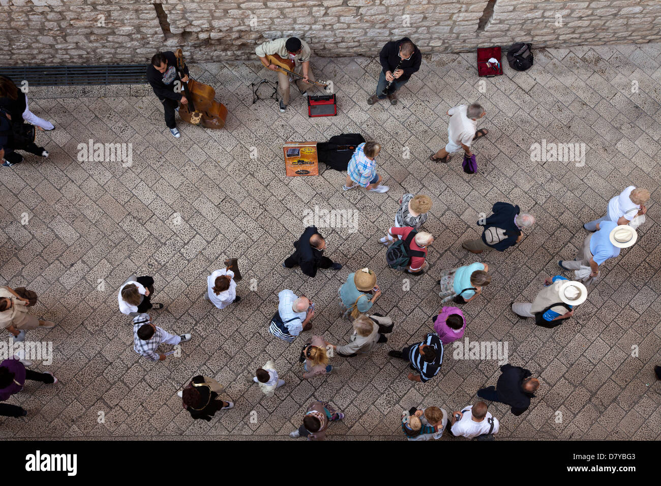 Regardant vers le bas sur des musiciens de rue et les touristes de passage à partir de la muraille de la ville qui englobe la vieille ville, Dubrovnik, Croatie. Banque D'Images