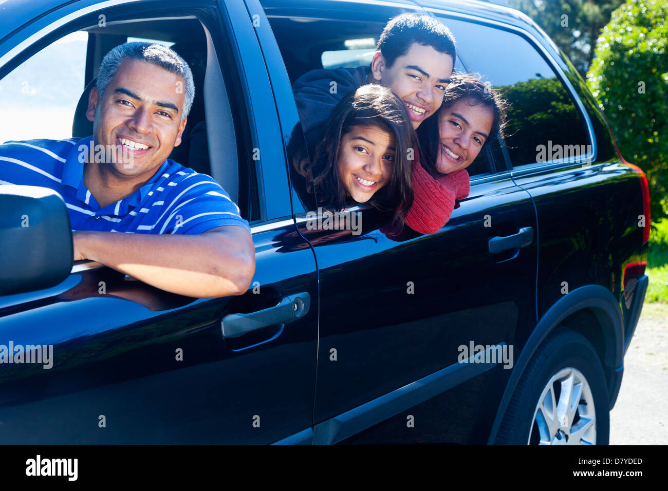 Hispanic family smiling in car Banque D'Images