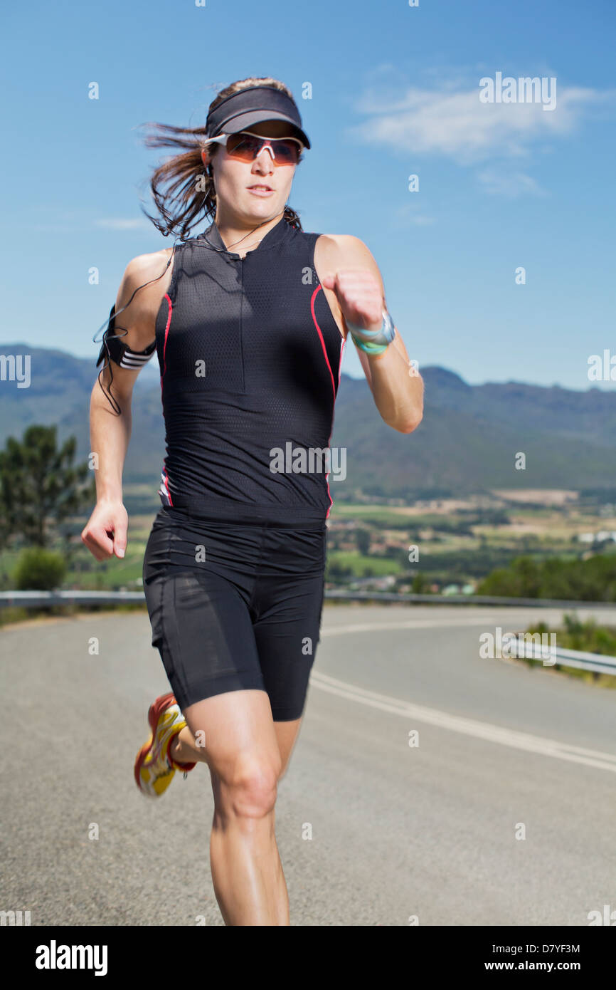 Woman running on rural road Banque D'Images