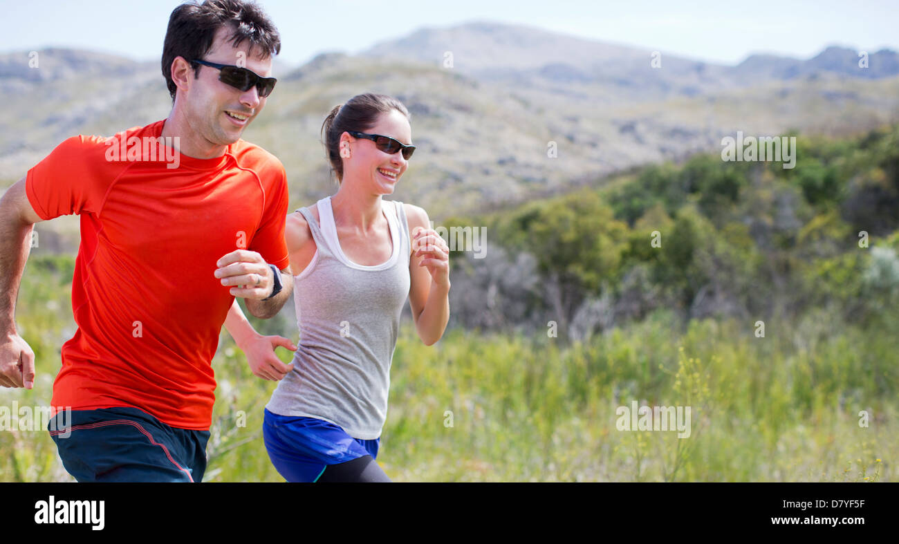 Couple running in rural landscape Banque D'Images