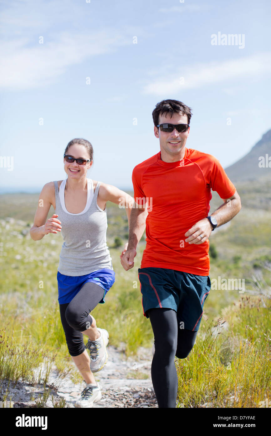 Couple running in rural landscape Banque D'Images