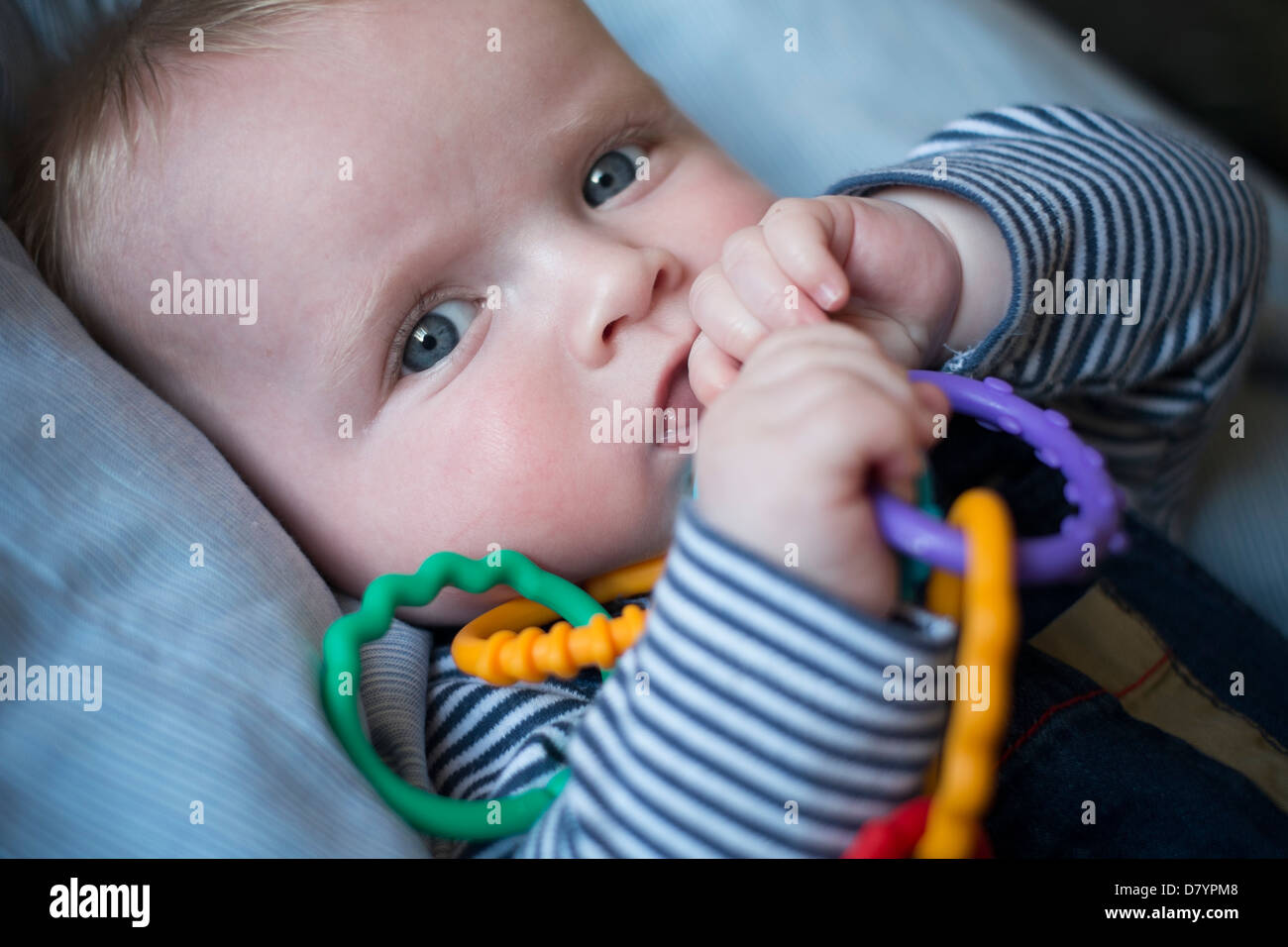 Un petit Garçon jouant avec anneaux de dentition. Banque D'Images
