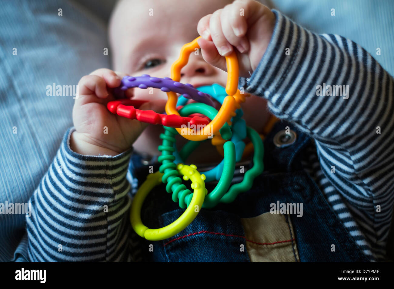Un petit Garçon jouant avec anneaux de dentition. Banque D'Images