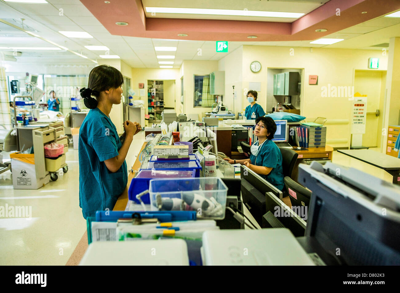 Les infirmières communiquent entre eux au sujet des fournitures médicales au cours de l'aire d'accueil dans une salle de soins intensifs. Banque D'Images