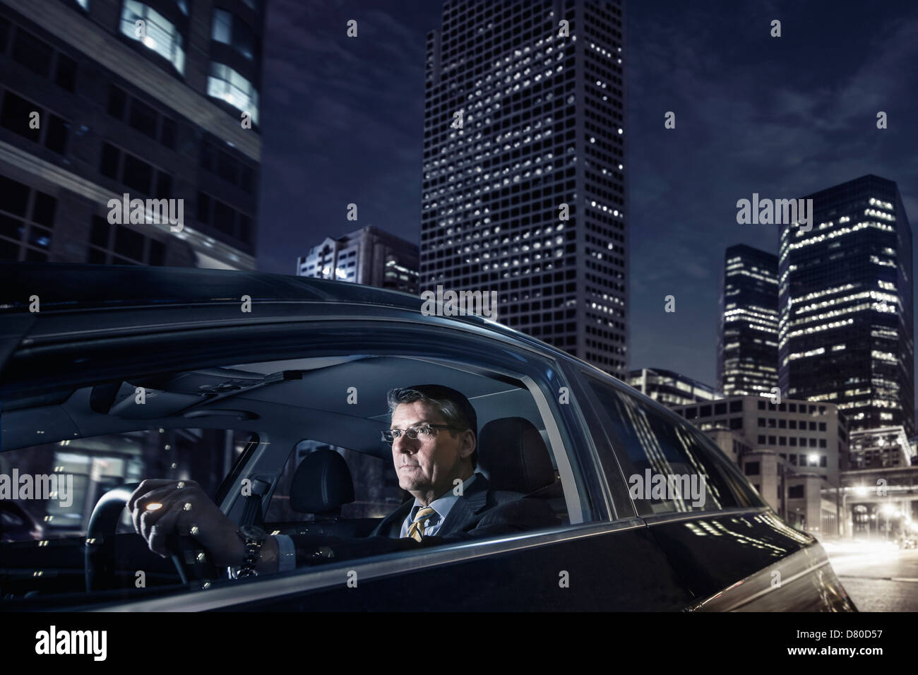 Caucasian businessman driving on city street Banque D'Images