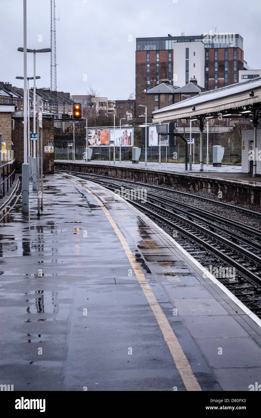 Clapham Junction déserte et plates-formes des voies de chemin de fer sous la pluie Banque D'Images