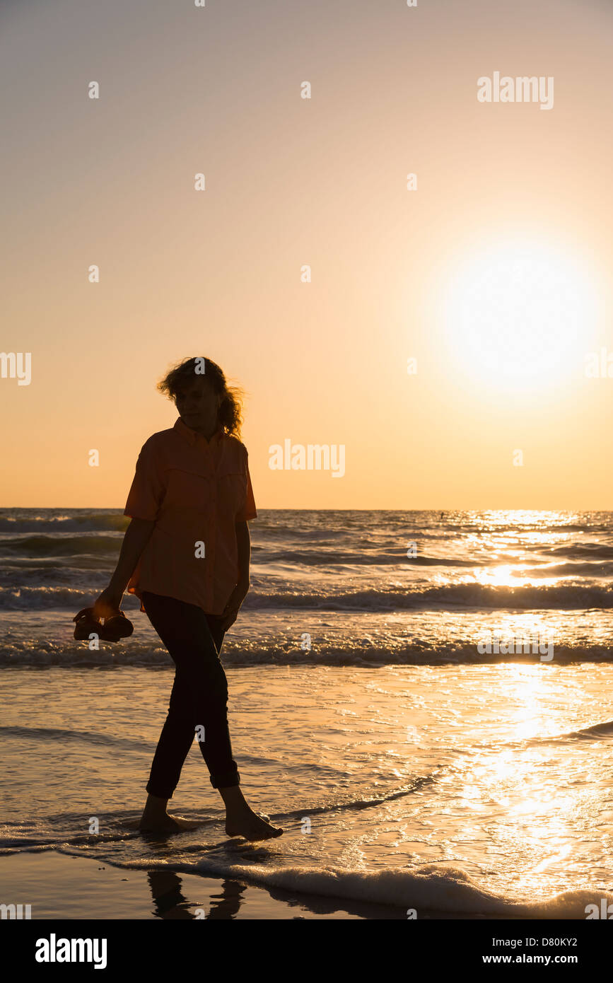 Femme marche sur la plage au coucher du soleil, femme de race blanche, 45 Indian Rocks Beach, Florida, USA Banque D'Images