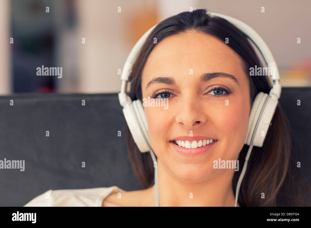 Portrait de femme simling avec son casque. elle écoute de la musique Banque D'Images
