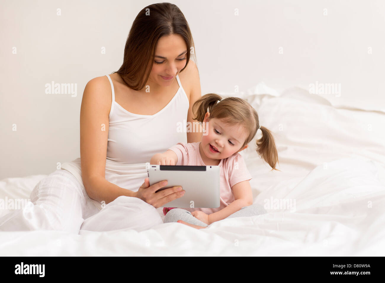 Petite fille jouant avec sa maman dans la chambre blanche Banque D'Images