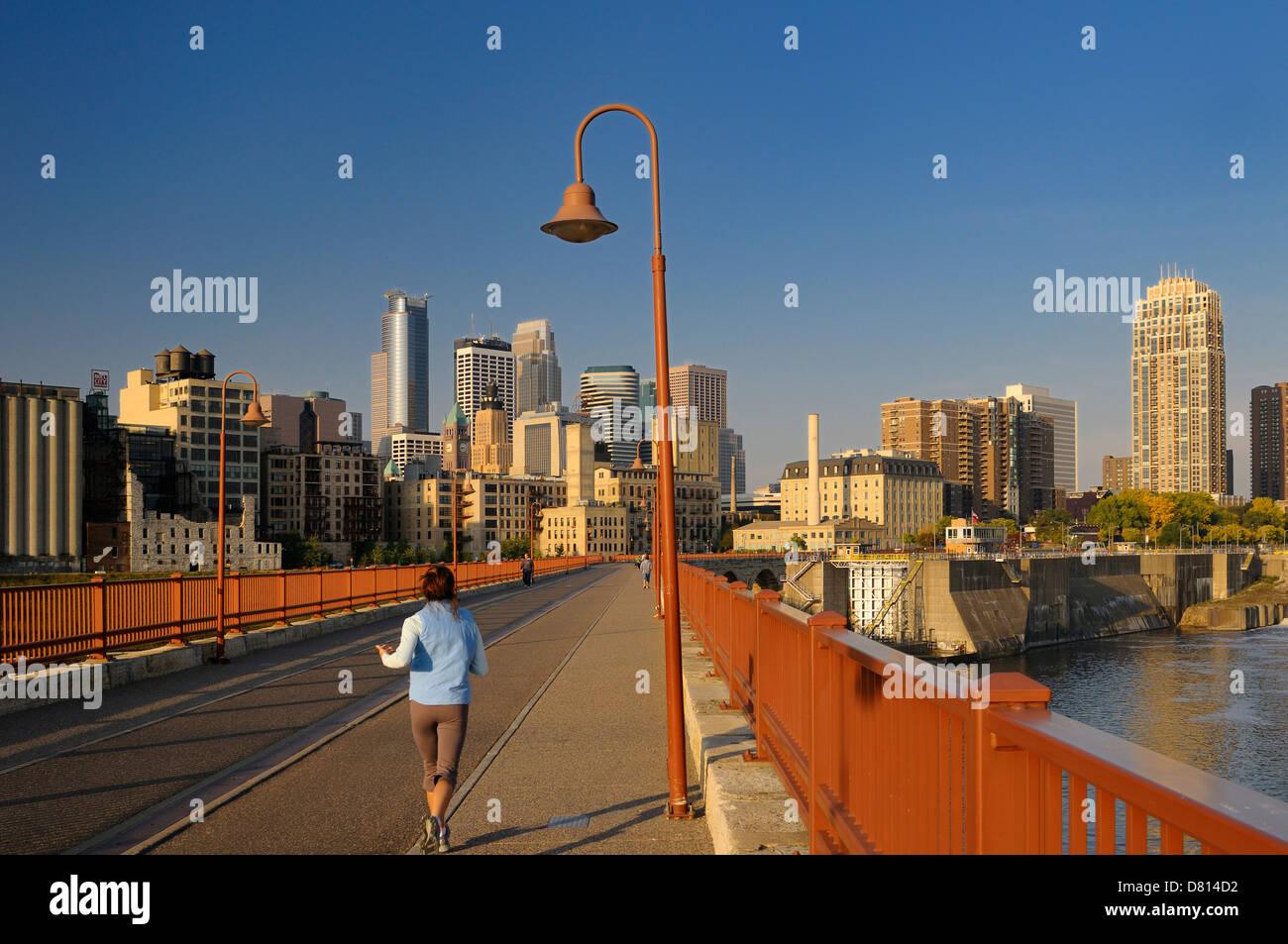 Tôt le matin, jogger et minneapolis tours tours d'horizon et lock et de la Dam 1 stone arch bridge au lever du soleil le Minnesota usa Banque D'Images