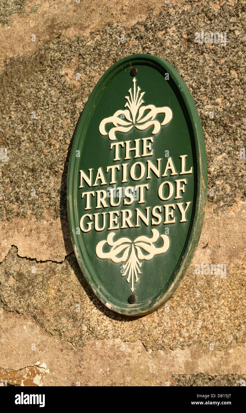 National Trust de Guernesey signe sur un mur de pierre Banque D'Images