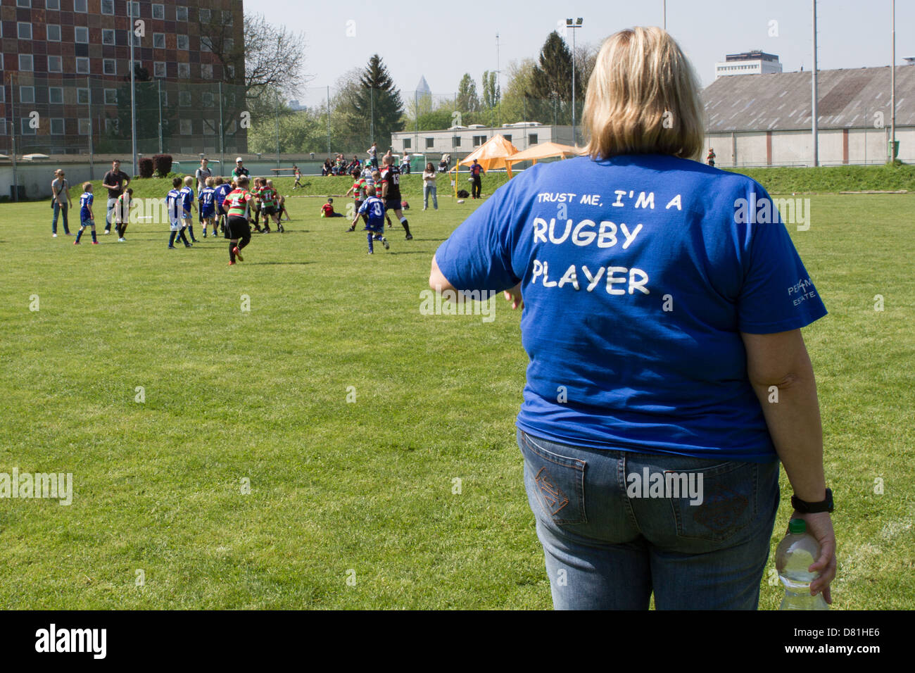 Une femme avec un 'faites-moi confiance, je suis un joueur de rugby' t-shirt montres un match de rugby pour les enfants Banque D'Images