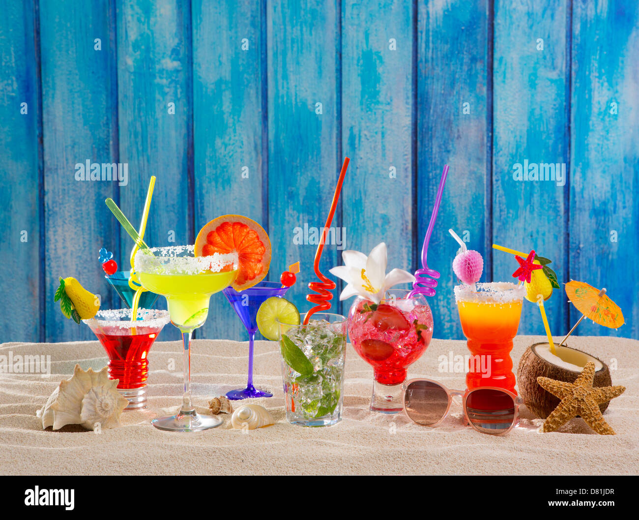 Des cocktails tropicaux colorés sur la plage au mur en bois bleu grunge Banque D'Images