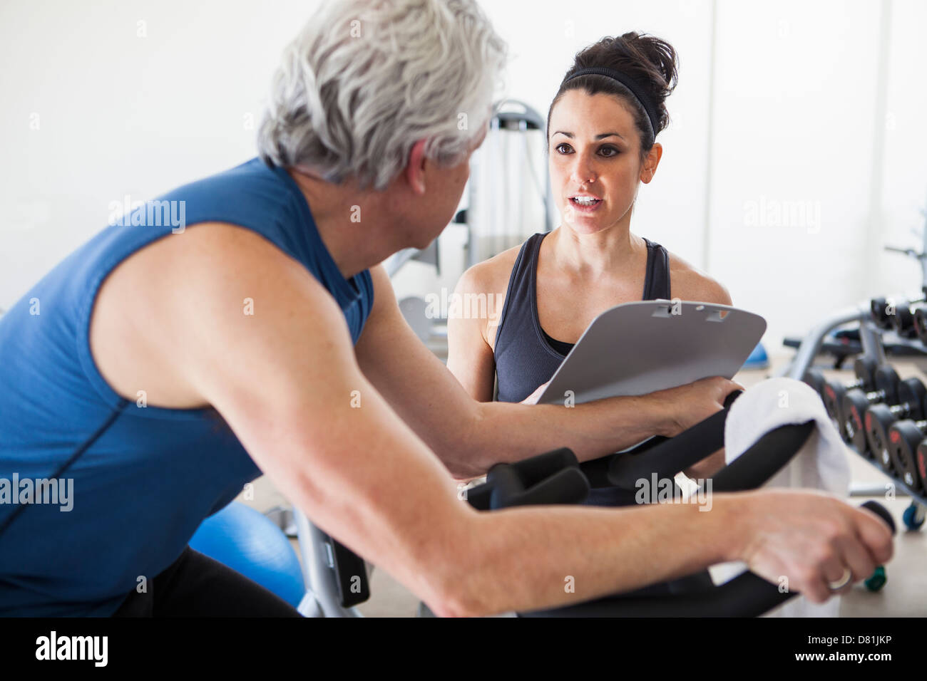 Older Hispanic Man working with trainer in gym Banque D'Images