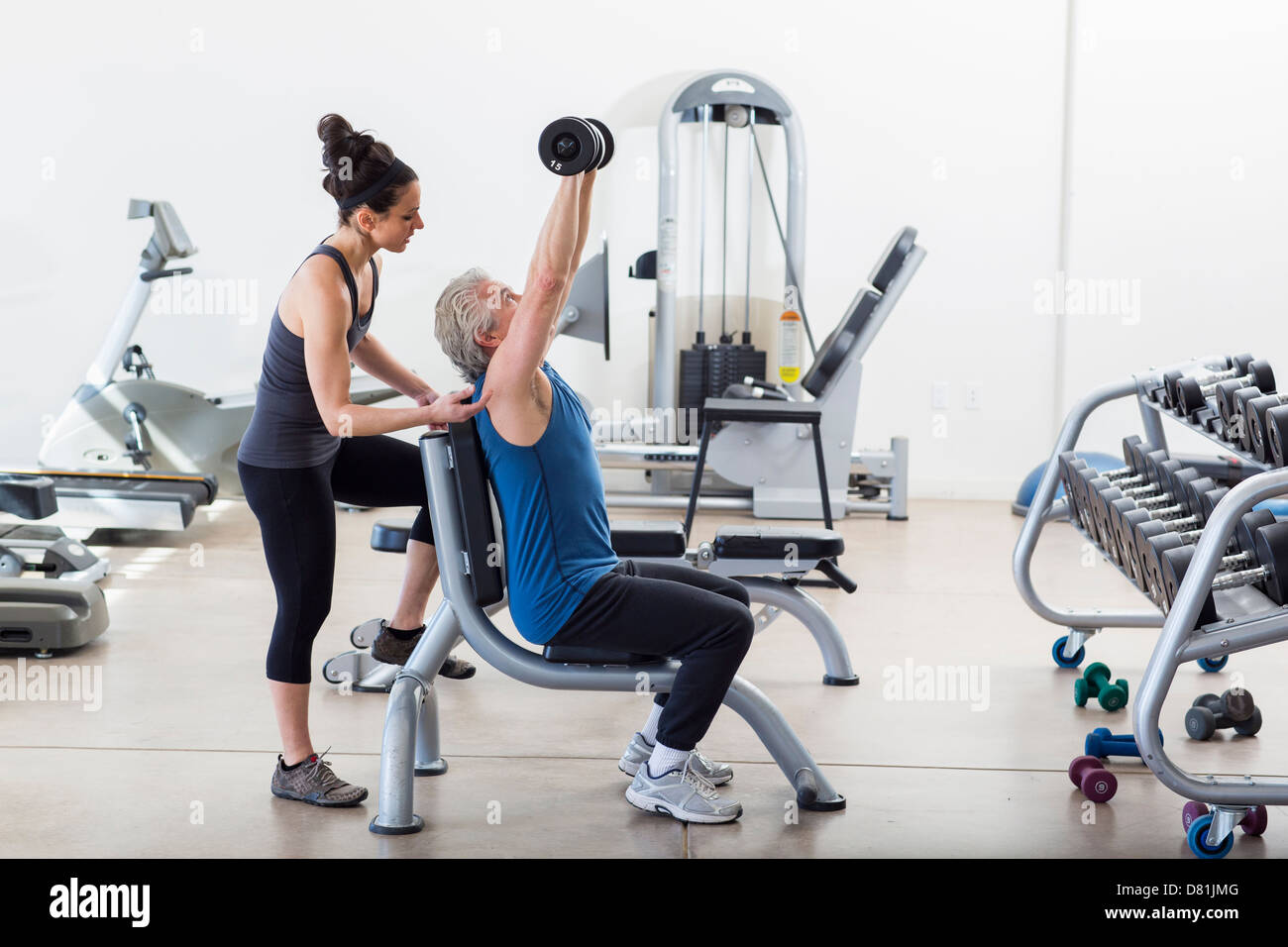 Older Hispanic Man working with trainer in gym Banque D'Images