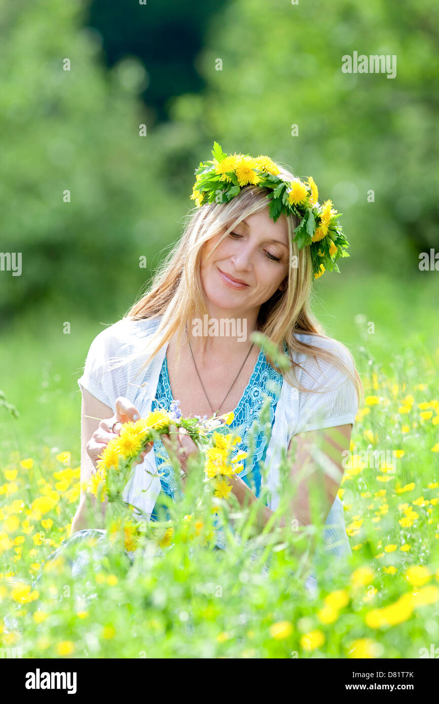 Femme avec couronne de fleurs dans une prairie de printemps implantation Banque D'Images
