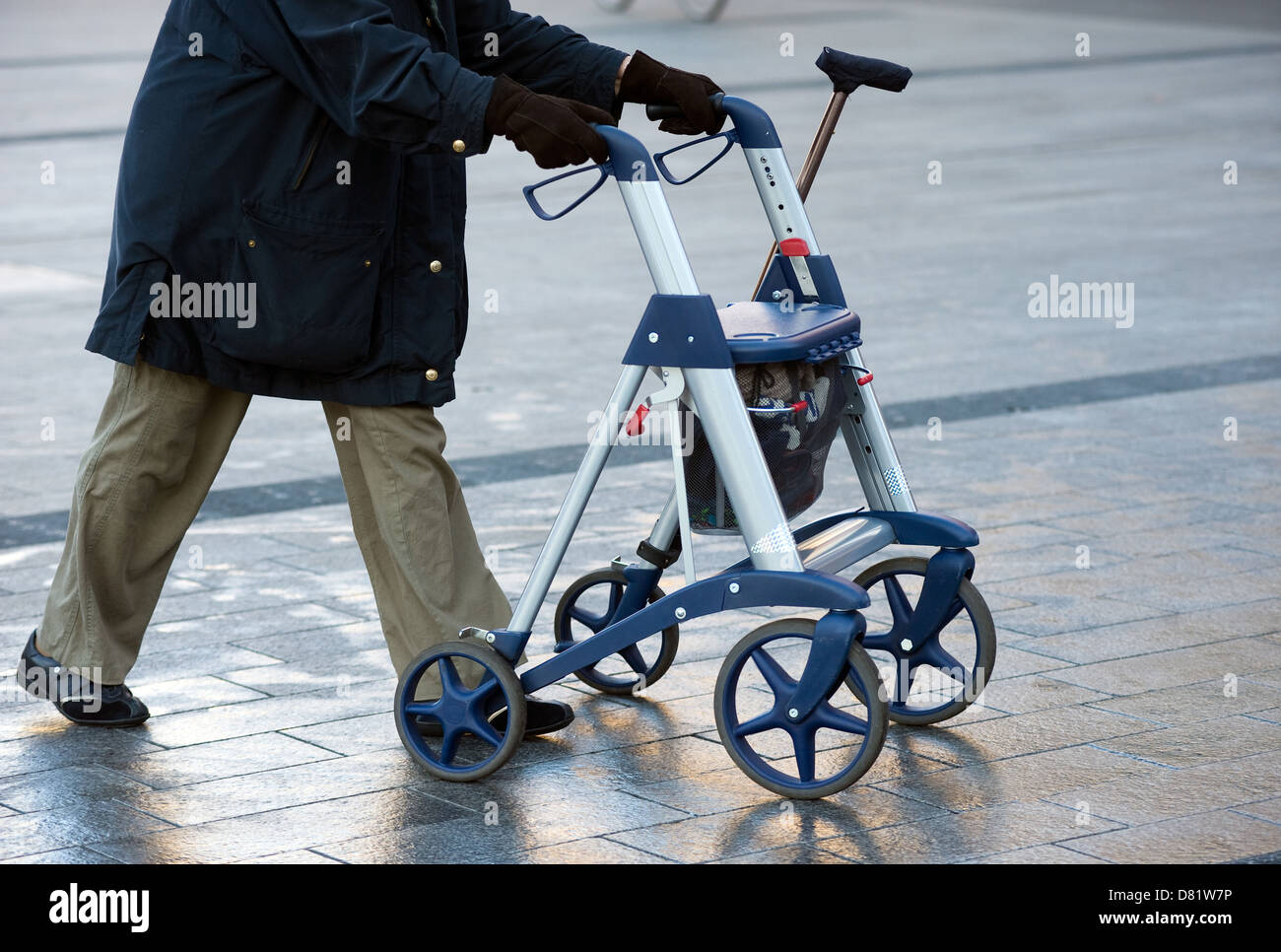 Une vieille femme marche dans la rue avec son déambulateur Banque D'Images