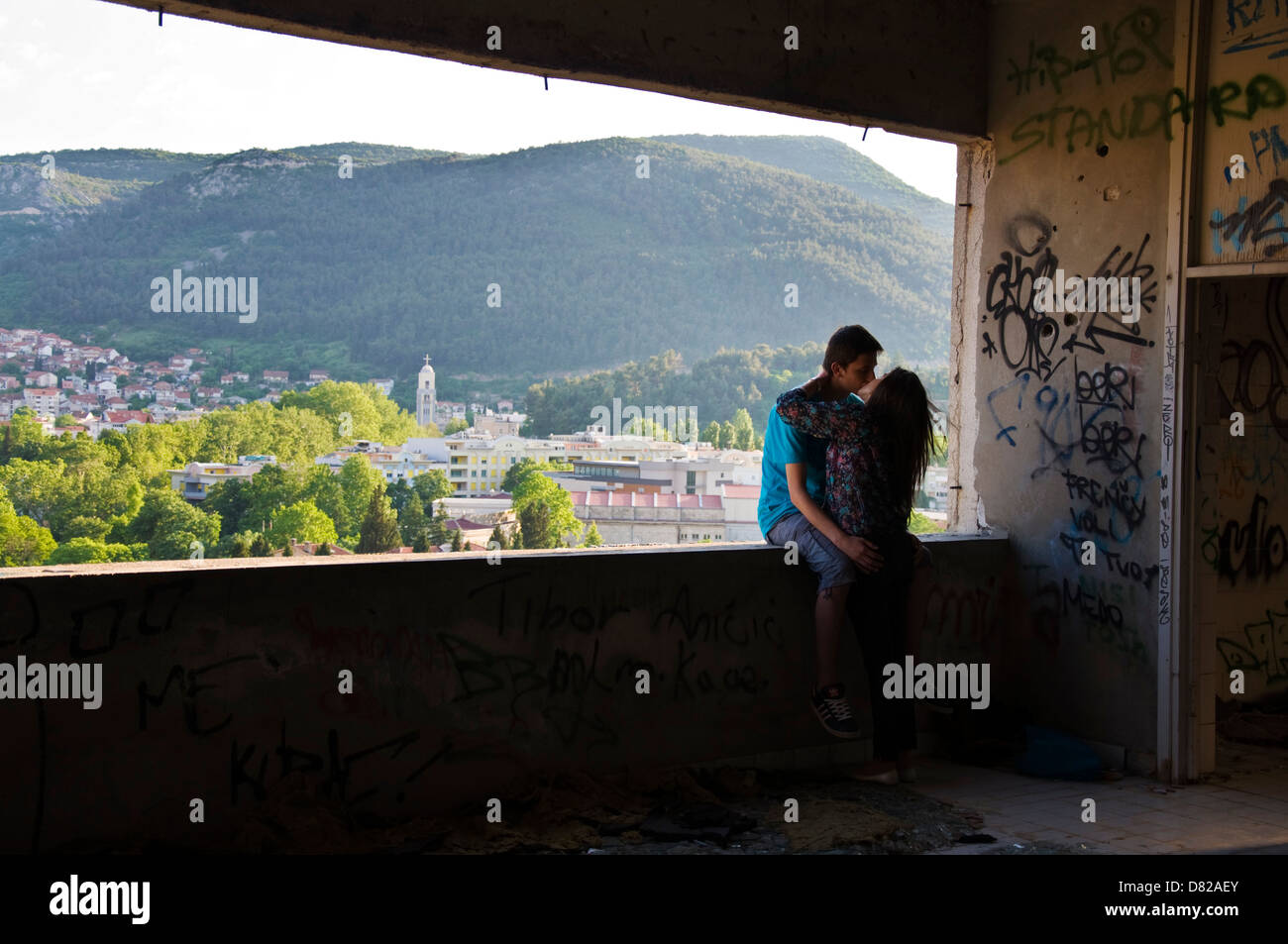 Couple baiser dans la guerre couvert de graffitis Staklena Banka Stara endommagé bâtiment dans Mostar Banque D'Images