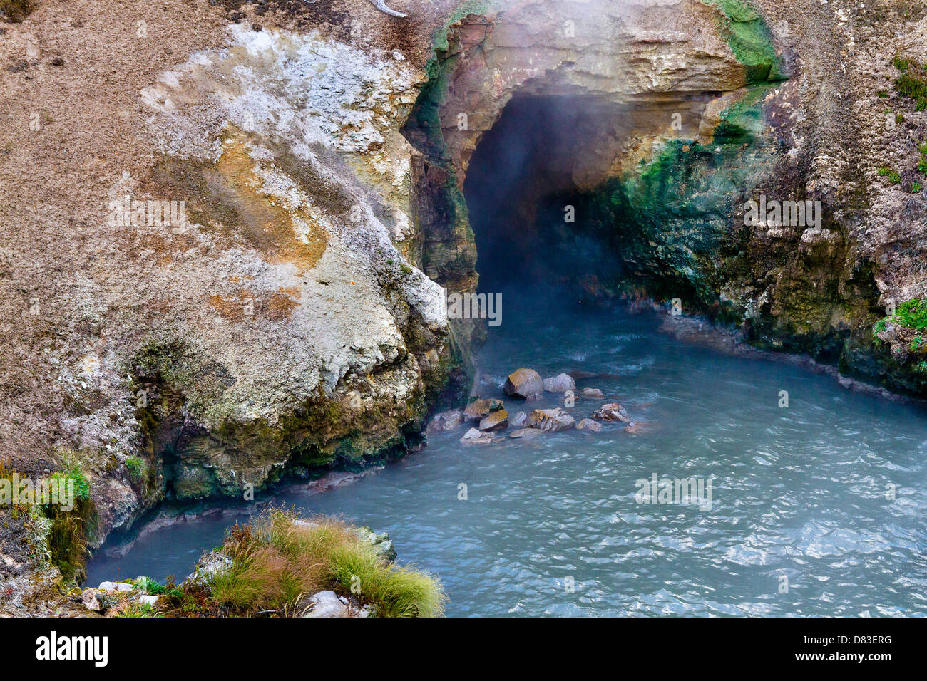 La vapeur se déverse de la bouche de la grotte dans l'étang bleu à la bouche du Dragon au printemps dans le Parc National de Yellowstone, Wyoming Banque D'Images