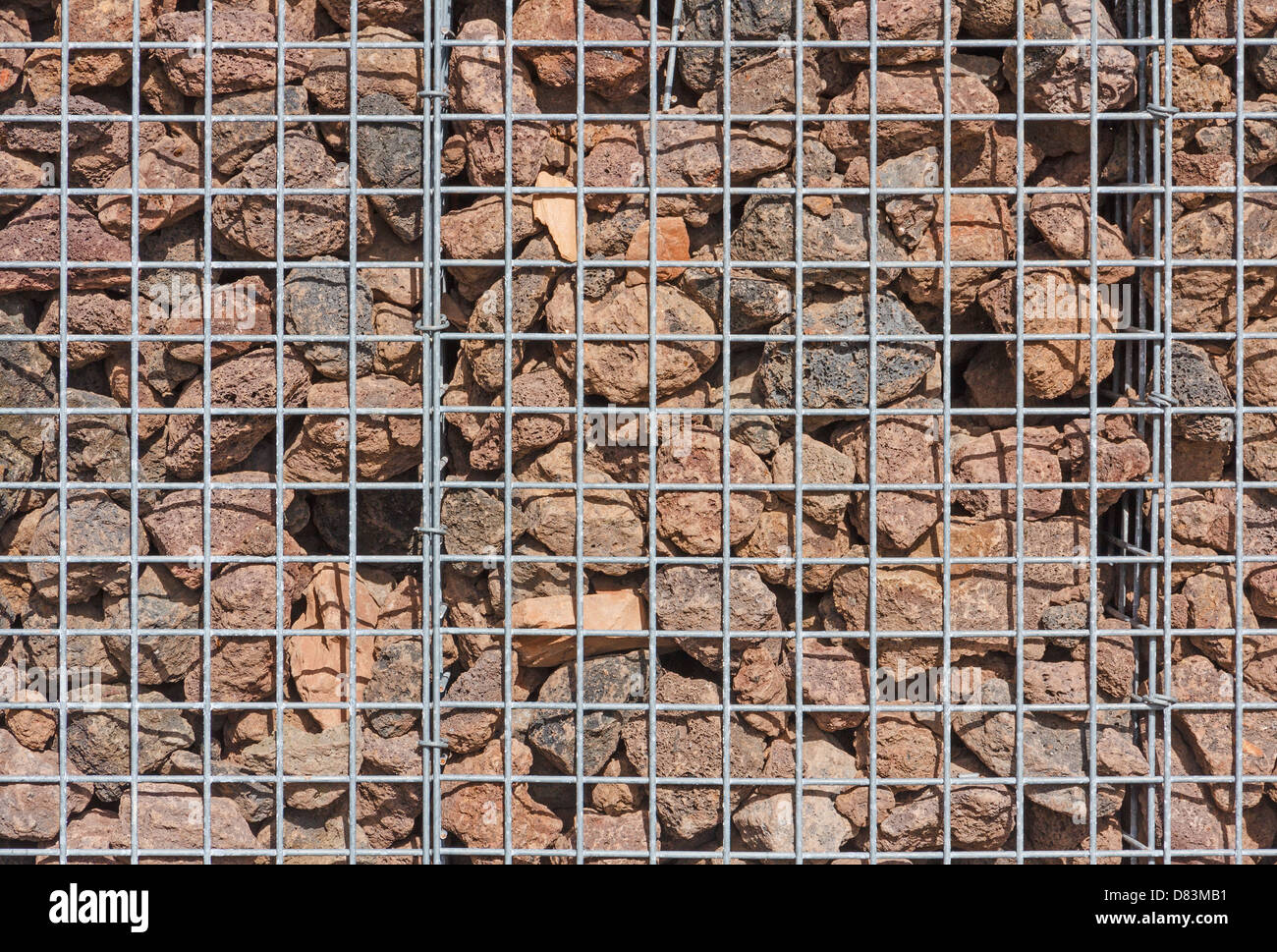 Mur de gabions remplis de pierres de lave dans la lumière du soleil Banque D'Images
