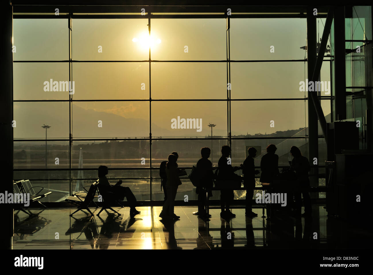 Attente de sécurité dans un aéroport avec soleil du matin à travers les fenêtres teintées. Banque D'Images