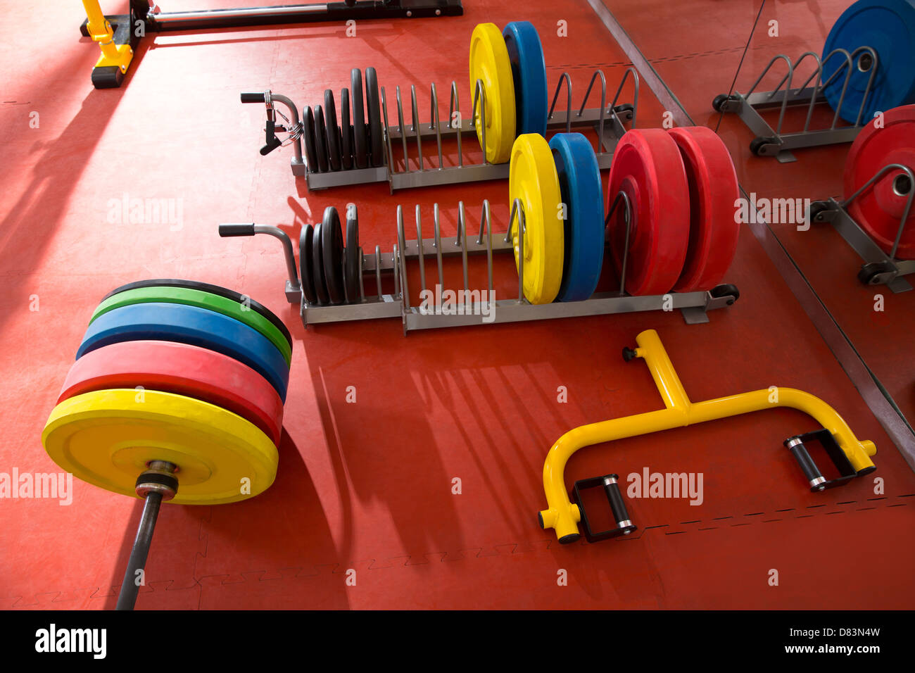 Salle de sport fitness Crossfit haltérophilie matériel coloré bar sur sol rouge Banque D'Images