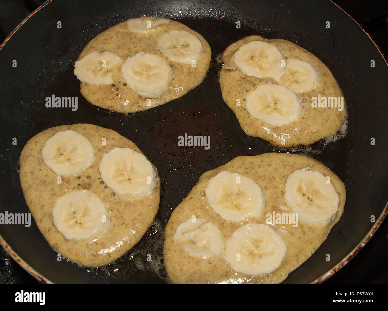 Pancakes à la banane complète dans une poêle à frire Banque D'Images