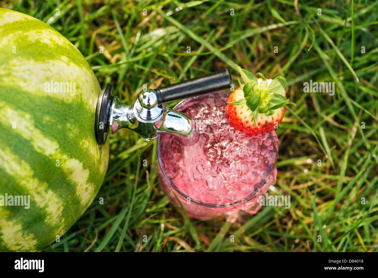 Un melon d'eau verte avec un robinet de jus de pastèque rose distribution Banque D'Images