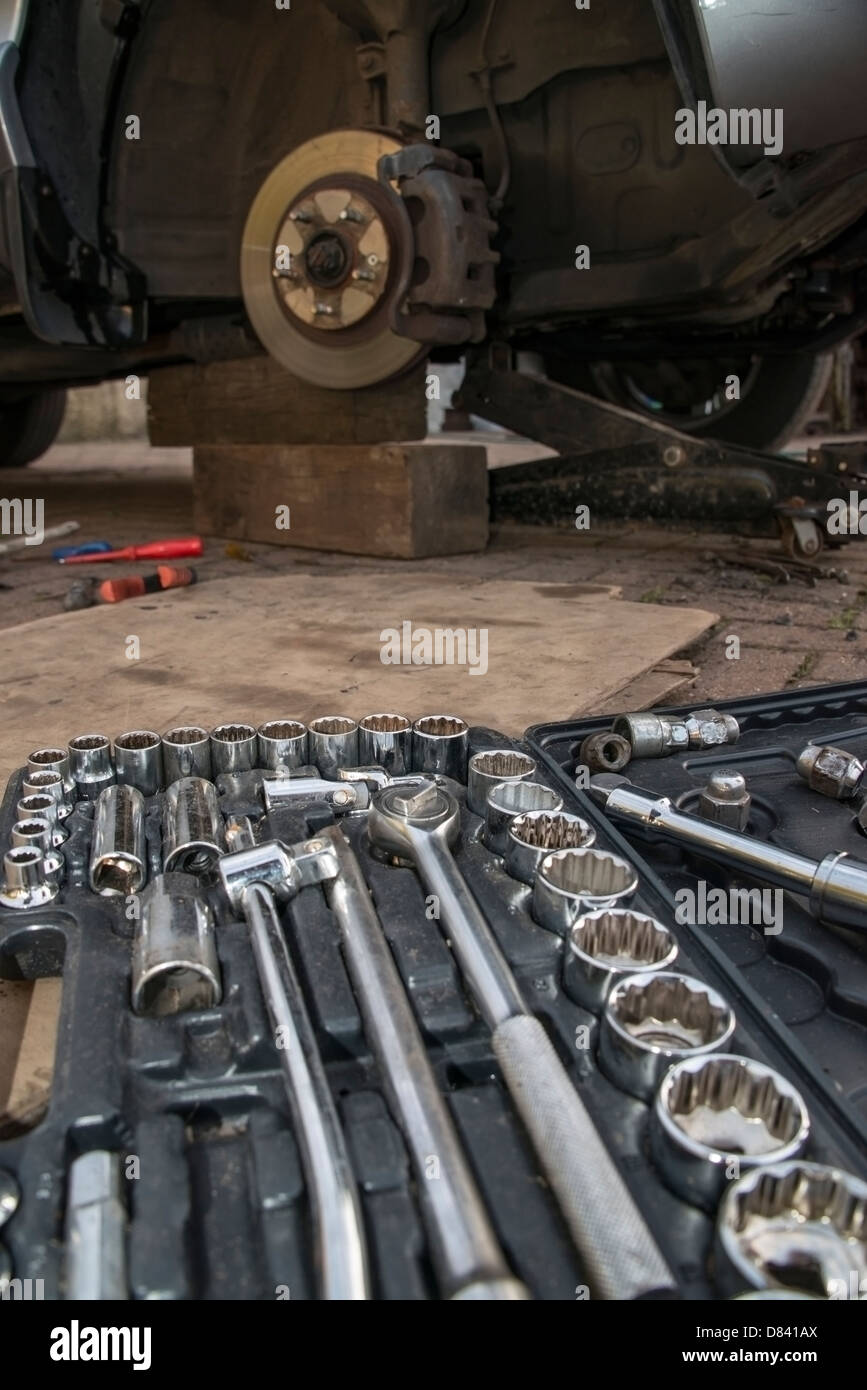 Un kit d'outils Jeu de douilles sur le sol par une voiture en réparation Banque D'Images