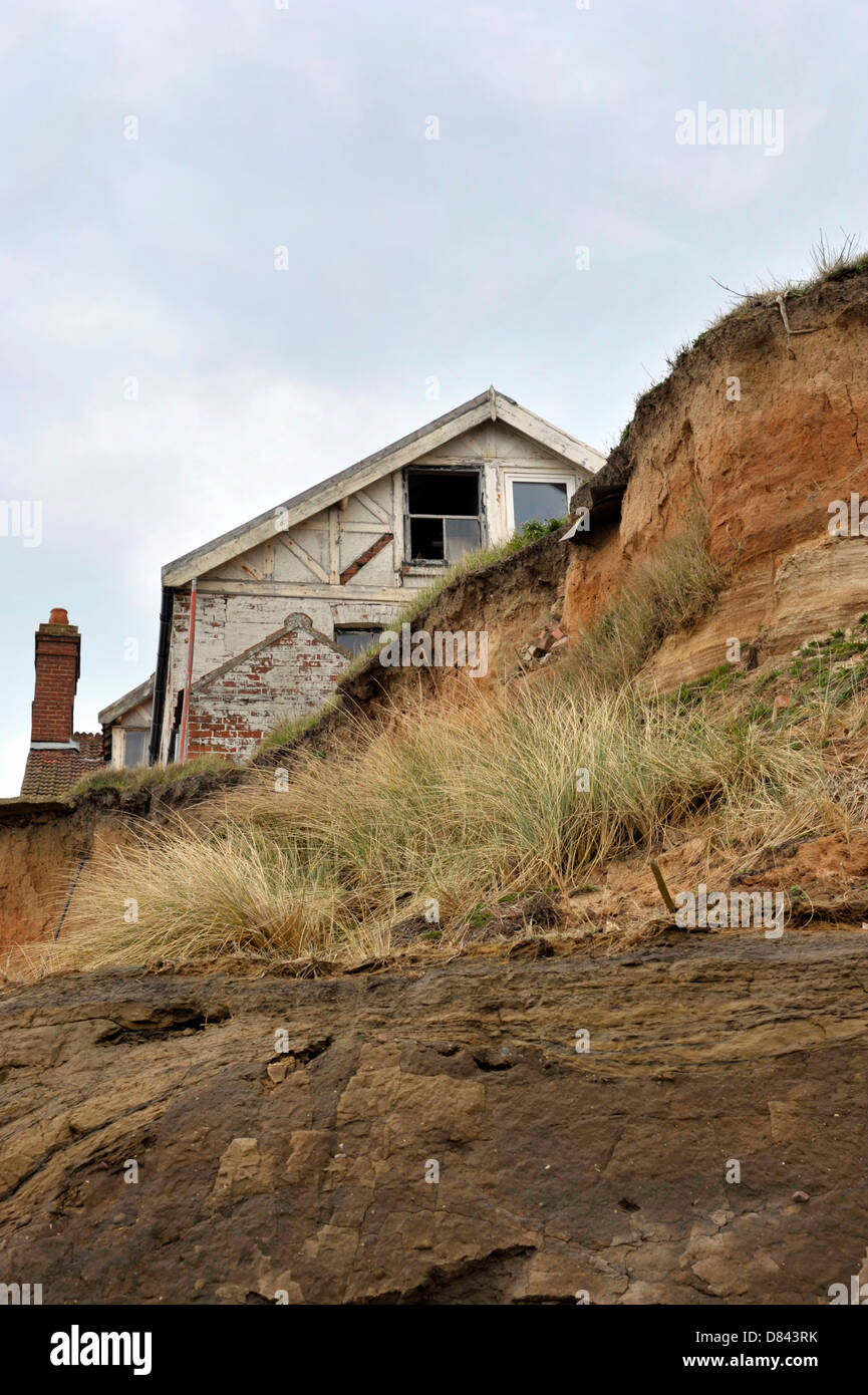 Maison sur le bord de la falaise à Happisburgh à Norfolk démontrant les niveaux d'érosion le long de la côte est. Banque D'Images
