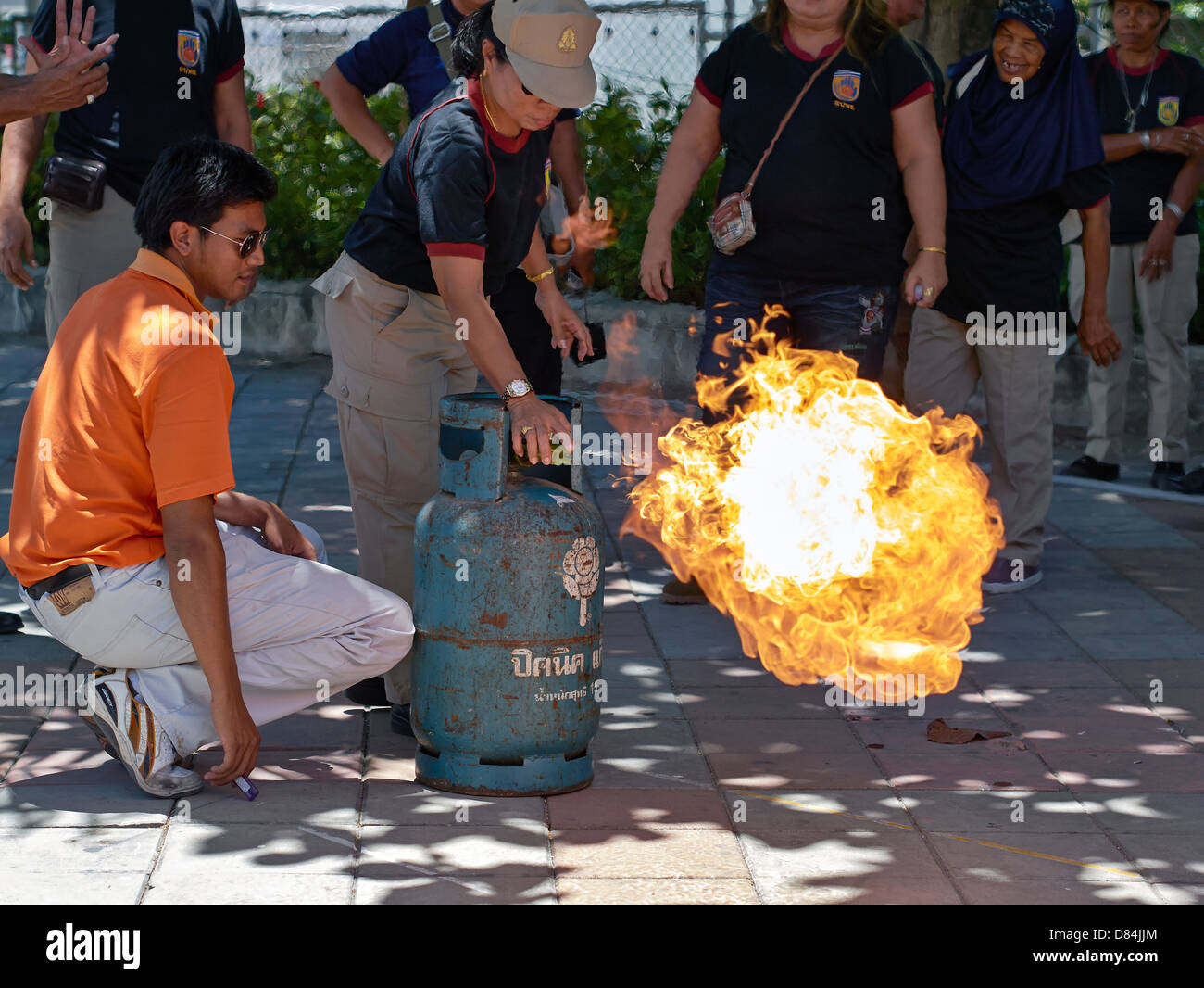 Formation sur la sécurité incendie des appareils domestiques.un agent des incendies de Thaïlande démontrant la méthode sûre pour éteindre la flamme d'une bouteille de gaz propane. Banque D'Images